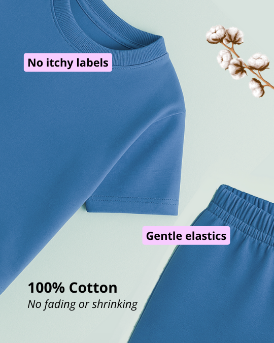 Blue children's pants with text about no itchy labels, gentle elastics, and 100% cotton on a light green background.