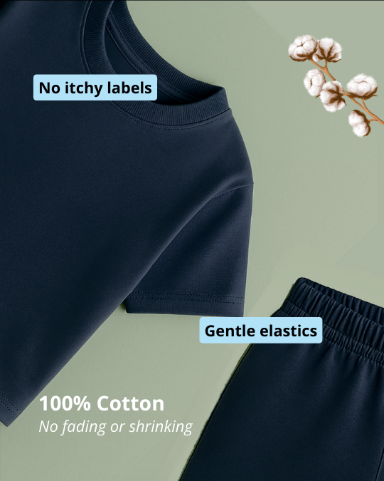 Navy blue pants with text about no itchy labels, gentle elastics, and 100% cotton on a green background.