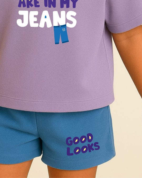 Person wearing a purple shirt with 'Are in my jeans' text and blue shorts with 'Good Looks' text on a beige background