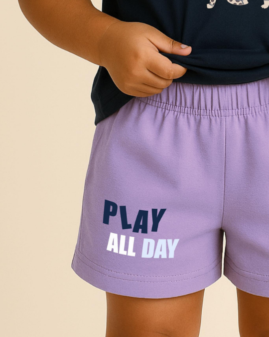 Purple shorts with 'PLAY ALL DAY' text worn by a person on a beige background