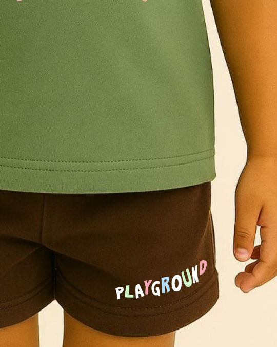 Child wearing green top and brown shorts with 'PLAYGROUND' text on a beige background