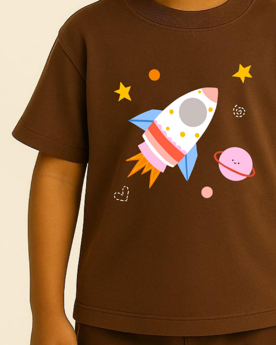 Brown t-shirt with a colorful rocket and planet design on a beige background
