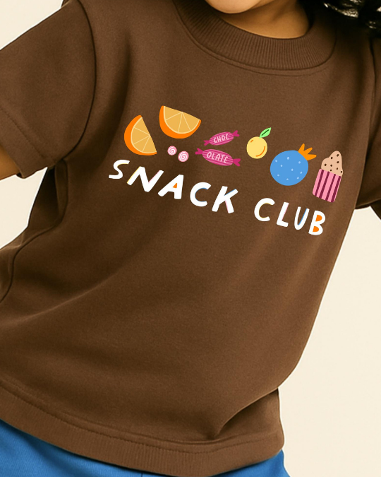 Brown sweatshirt with 'Snack Club' text and food graphics on a beige background