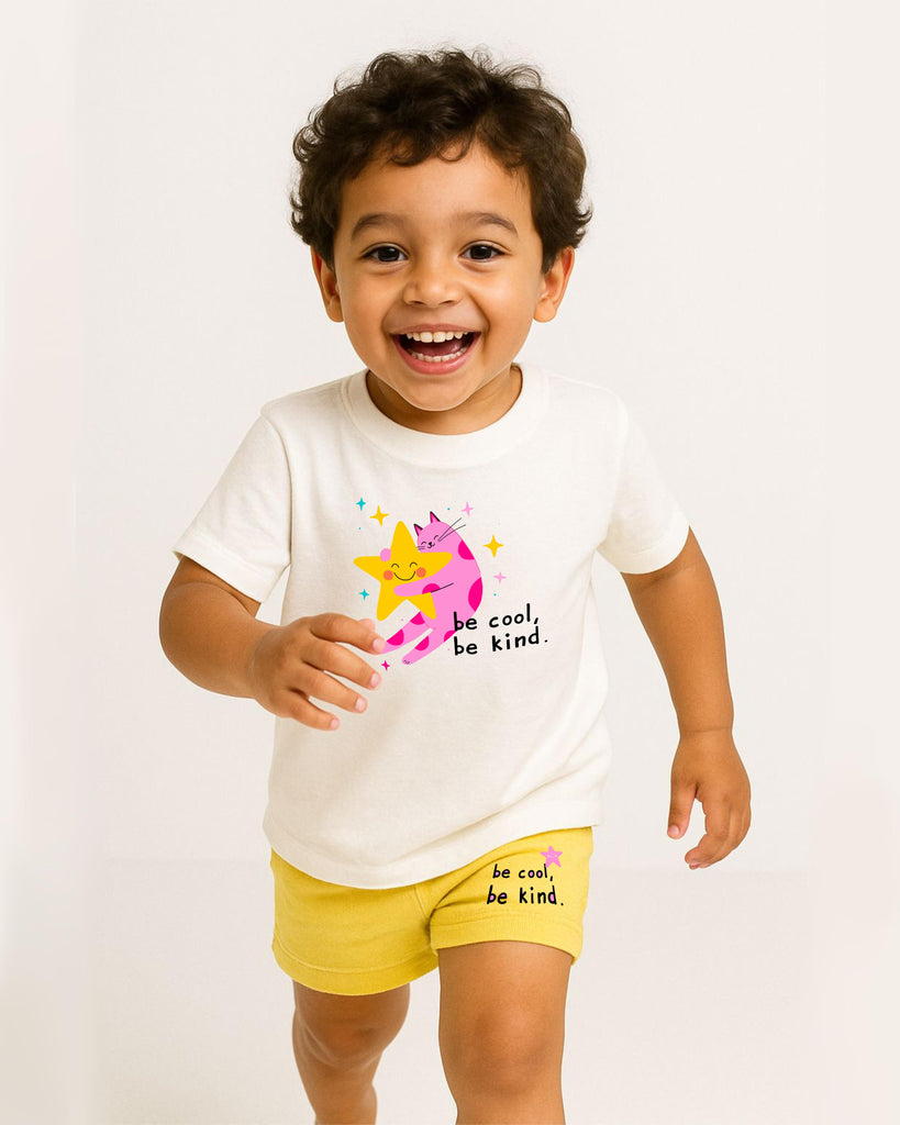 Child wearing a white t-shirt with a colorful design and text, standing against a plain background