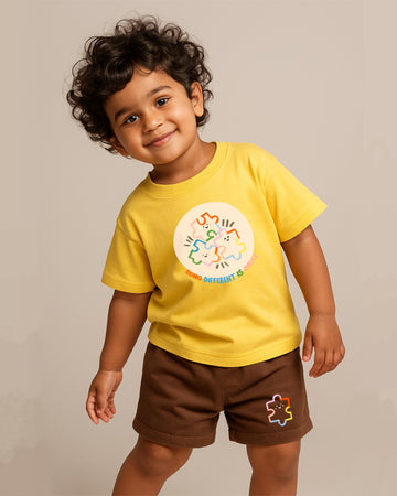 Child wearing a yellow t-shirt with a colorful design on a beige background