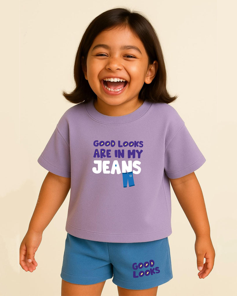 Child wearing a purple t-shirt with 'Good looks are in my jeans' text on a beige background