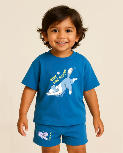 Child wearing a blue t-shirt and shorts with a cartoon design on a beige background