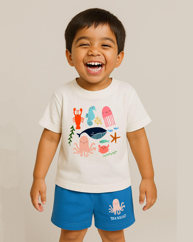 Child wearing a white t-shirt with colorful sea-themed graphics and blue shorts on a beige background